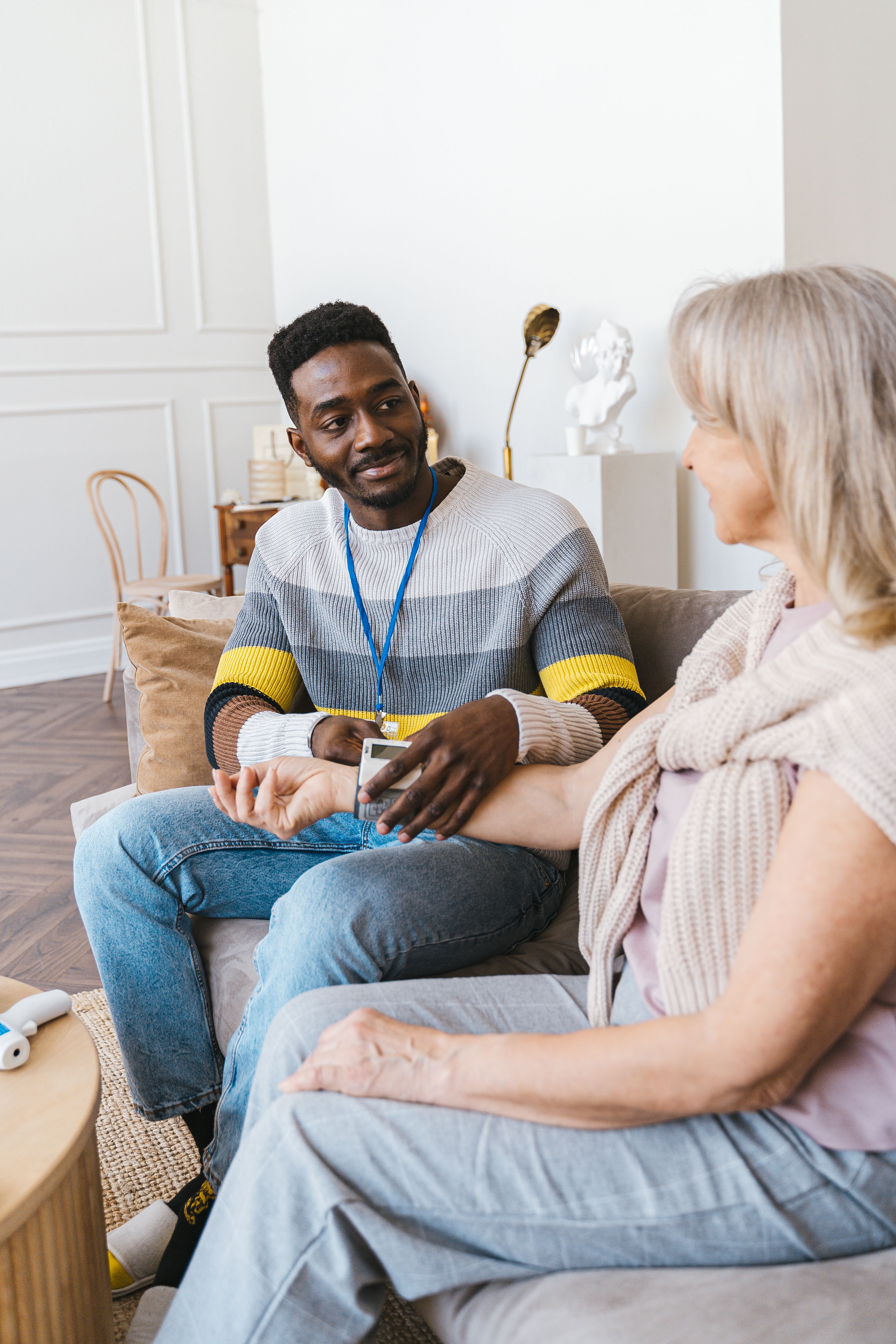 Caregiver in warm conversation with elderly woman at home