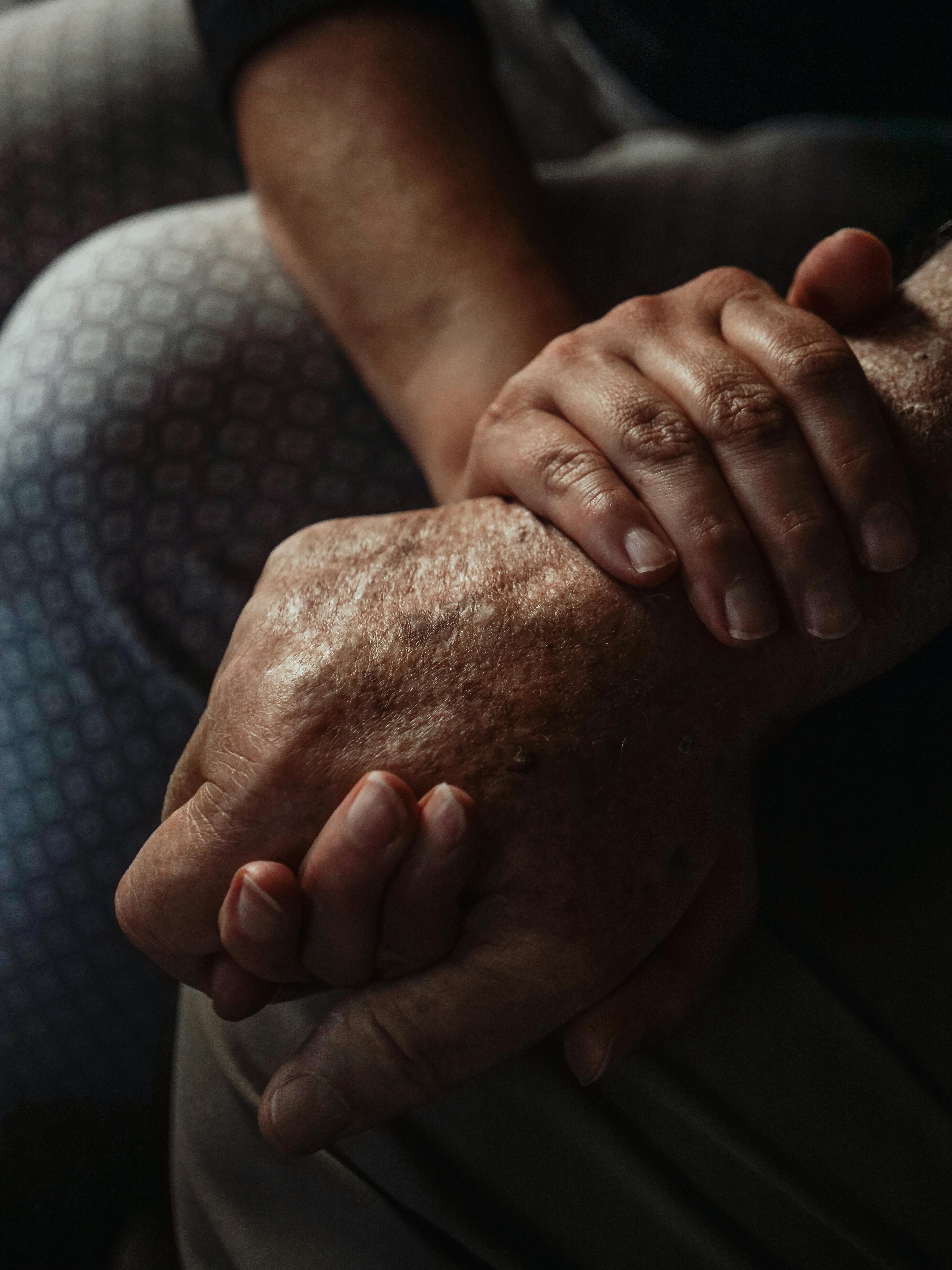 Caregiver holding hands with client in a moment of comfort